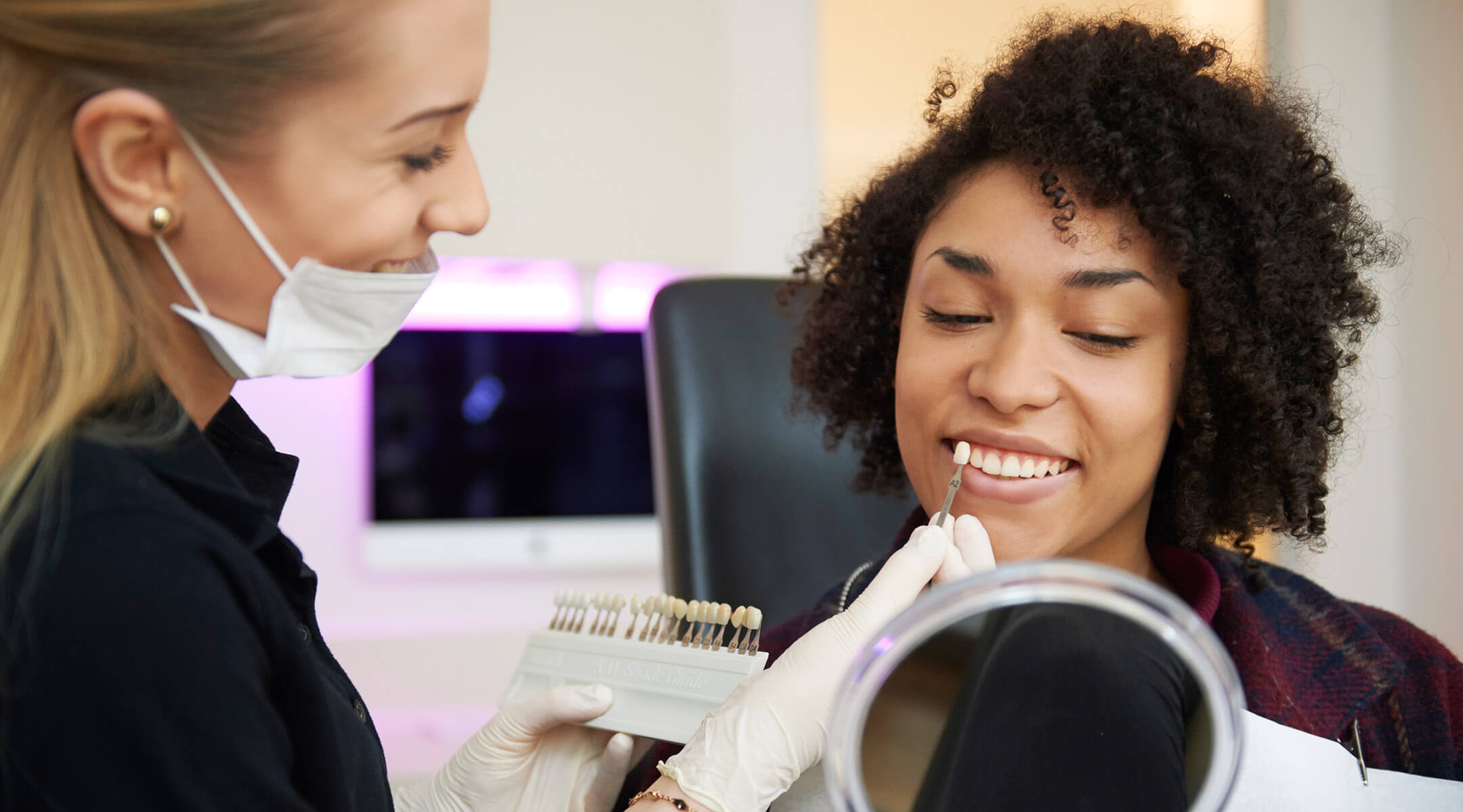 Eine Patientin prüft das Ergebnis der Bleaching Behandlung.